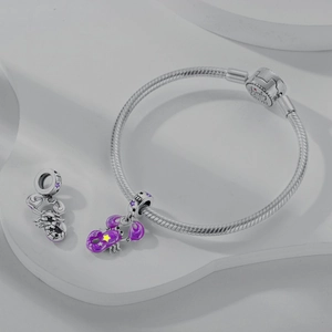 Detailed view of silver snake chain bracelet with purple enamel Scorpio charms and stars