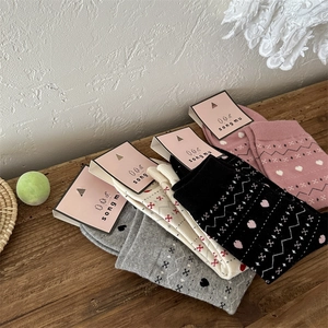 Détail de chaussettes en coton tricoté avec motifs festifs de cœurs et de flocons