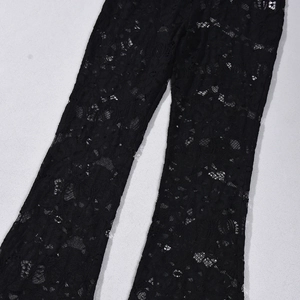 Gros plan sur la dentelle noire aux motifs floraux ajourés pour ce pantalon
