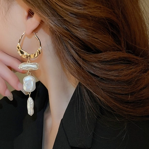 Close-up of Baroque pearl drop earrings with hammered gold rings on model