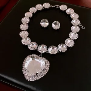 Luxury heart-shaped crystal jewelry set with necklace and earrings on black leather