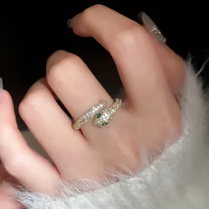 Gold plated snake ring with pavé zircons and green gemstone eyes for a luxury look