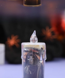 Macro detail of Halloween LED candle light featuring a Grim Reaper and bat pattern print