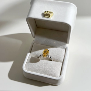 Detailed macro of S925 silver ring with yellow oval-cut zircon in a white gift box
