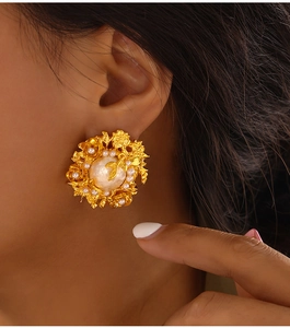 Vue détaillée de boucles d'oreilles vintage en or avec perles incrustées et fleurs