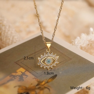 Detail showing gold evil eye pendant dimensions 2.1cm x 1.8cm with blue zircon stone