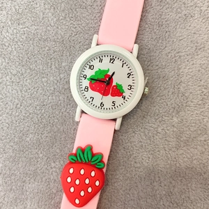 Detail of pink silicone strap with 3D strawberry charms and white dial on kids' watch