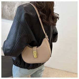 Detail einer beigen Crescent Hobo-Tasche mit polierter goldener geometrischer Metallschnalle