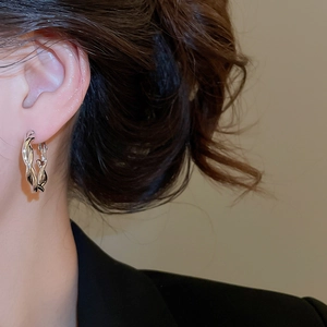 Nahaufnahme eines Models mit minimalistischen silbernen gedrehten Creolen