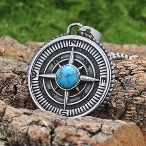 Macro shot of Viking compass pendant with turquoise inlay on natural bark background