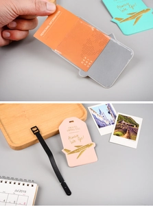Detail showing grey and pink faux leather luggage tags with black adjustable straps
