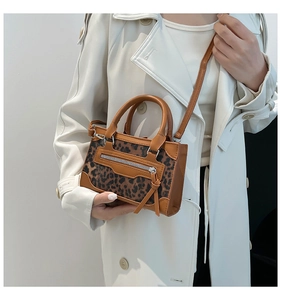 Detalle de bolso con estampado de leopardo, cremalleras y detalles en cuero marrón