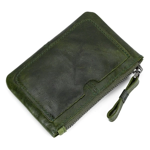 Macro shot of dark green genuine leather coin purse showing premium pebble grain texture