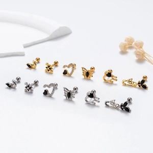 Detailed display of gold and silver surgical steel ear studs with black zircon accents