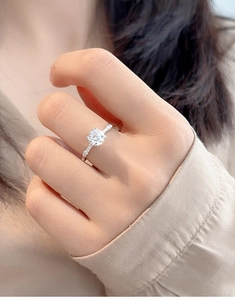 Close-up of a 1-carat moissanite ring with side accent diamonds on a S925 silver band