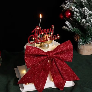 Large red glitter bow and Merry Christmas cake topper on a festive white cake