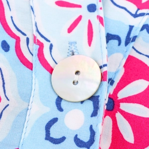 Detailed close-up of geometric floral print fabric and pearlescent white button detail