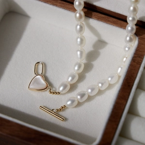 Freshwater pearl necklace with gold heart pendant and OT buckle in a jewelry box