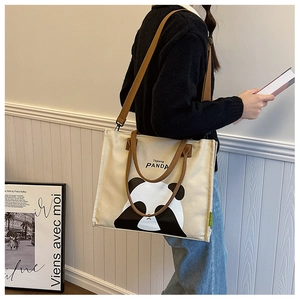 Detail of canvas tote bag showing the cute panda graphic and adjustable shoulder strap