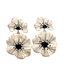 Elegant cream flower earrings with black accents and gold hardware on white background