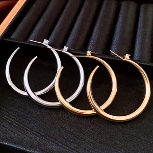 Detail view of 18k gold and silver plated hoop earrings set in a black jewelry display box