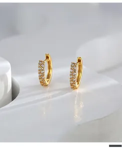 Detailed macro view of gold-plated hoop earrings featuring double rows of micro-pave white zircons