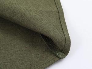 Vue détaillée de la texture tissée vert olive et des coutures du costume en coton et lin