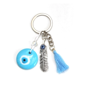 Detail of pink evil eye keychain with silver feather pendant and soft light blue tassel