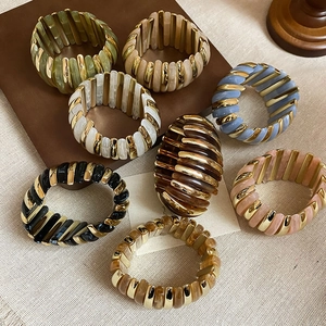 Detailed macro view of vintage elastic bracelets featuring colorful resin and metal segments