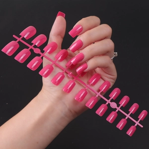 Macro view of long square fuchsia press-on nails with high-gloss UV coating and 24 piece set