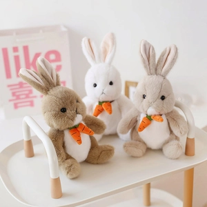 Plush bunny toy set in white and brown with carrot charms on a white display stand