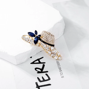 Detailed macro view of hat brooch with blue gemstones and rhinestones on stone pedestal