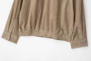 Détail du zoom sur l'ourlet côtelé et la texture en daim de cette veste bomber kaki