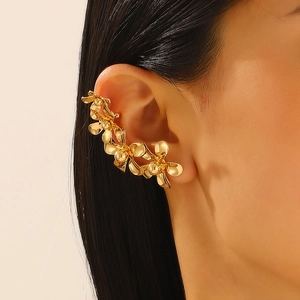 Vintage gouden blad- en bloemoorring voor dames, close-up van het sieraad op het oor