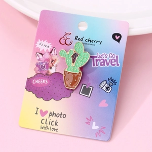 Detail of creative green cactus enamel brooch on a pink decorative background card