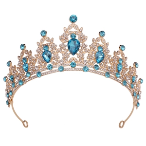 Detail of a golden bridal tiara featuring blue teardrop rhinestones and sparkling crystals