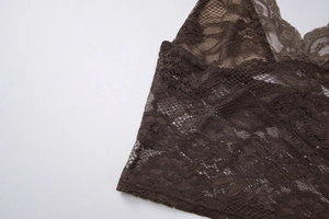 Vue détaillée de dentelle marron foncé montrant les motifs floraux complexes et texture