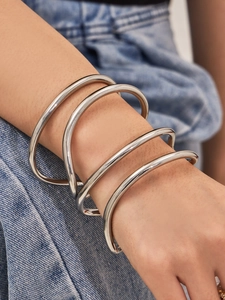 Dettaglio del bracciale a spirale in argento su modella con sfondo in denim