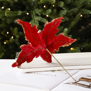 Feuille d'érable de Noël en velours rouge avec bordures dorées sur fond festif