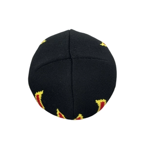 Close-up of the black knit beanie featuring a vibrant red and yellow flame jacquard pattern