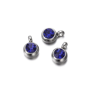 Macro detail of silver bezel pendants with faceted navy blue crystals for DIY jewelry making