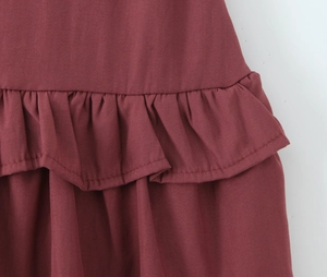 Detailed macro shot showing layered ruffle texture and burgundy fabric of the dress