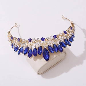 Macro detail of golden bridal tiara with royal blue crystals and floral alloy patterns