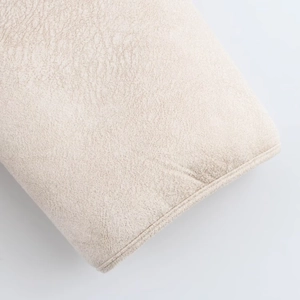 Detailed close-up of premium beige faux leather texture with precision stitching on seams