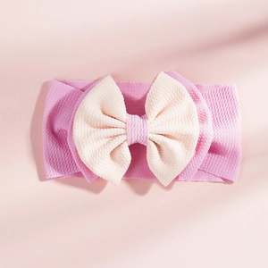 Close-up of pink and beige waffle texture fabric double bow headband for infants