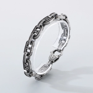 Detail of vintage punk silver bracelet with engraved geometric clasp on acrylic stand