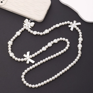 Elegant white pearl phone lanyard with bowknots and heart beads on a black background