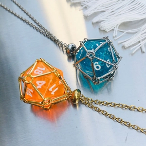 Macro view of blue and orange D20 resin dice pendants in geometric metal cages