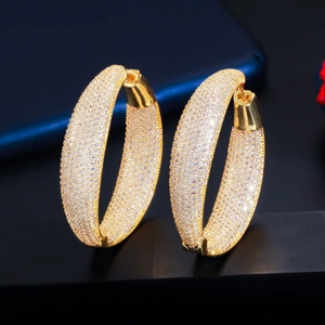 Close-up of gold-plated hoop earrings with micro-pave cubic zirconia on dark base