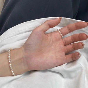 Elegant white round pearl ring and bracelet set on hand, classic minimalist jewelry